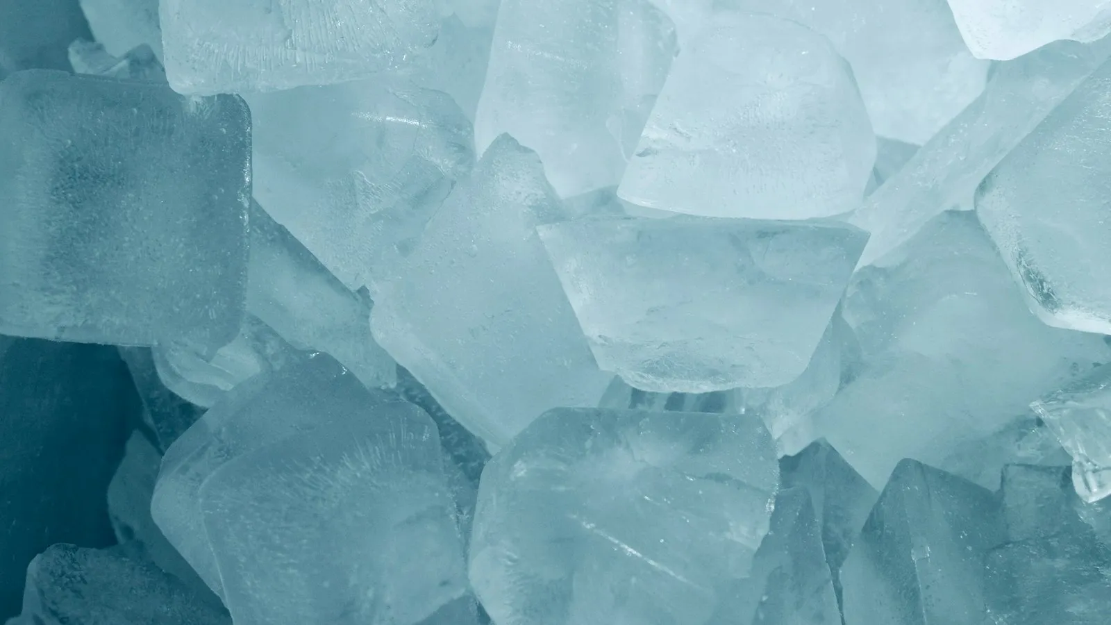 A pile of clear ice cubes with a blue tint