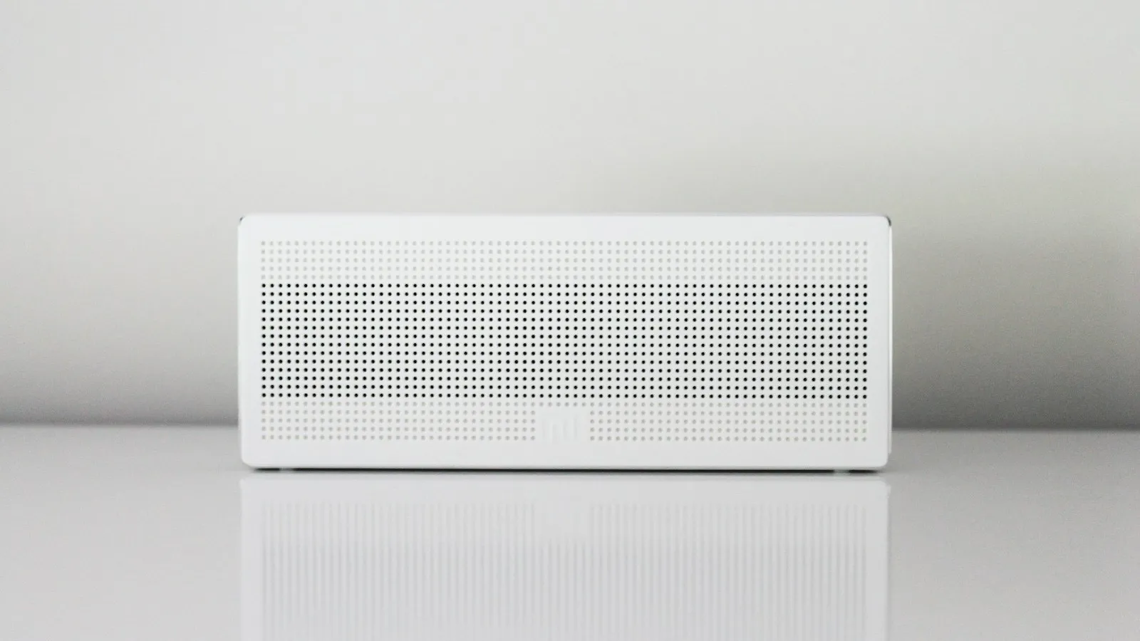 A white rectangular appliance on a table against a white wall