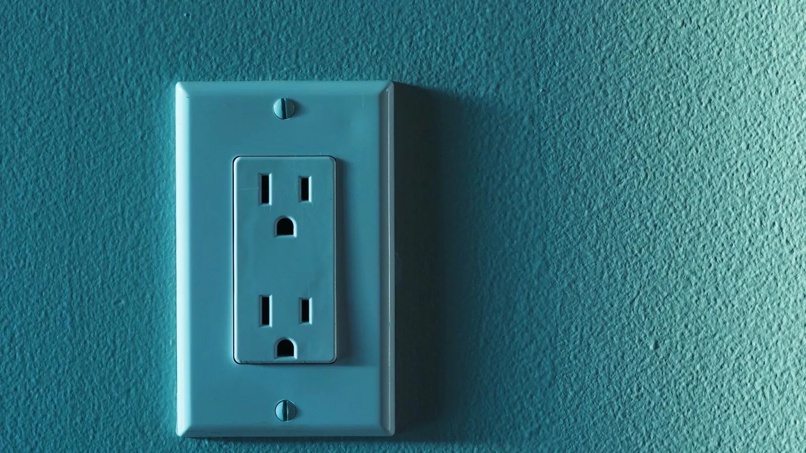 Electrical outlet on a teal wall