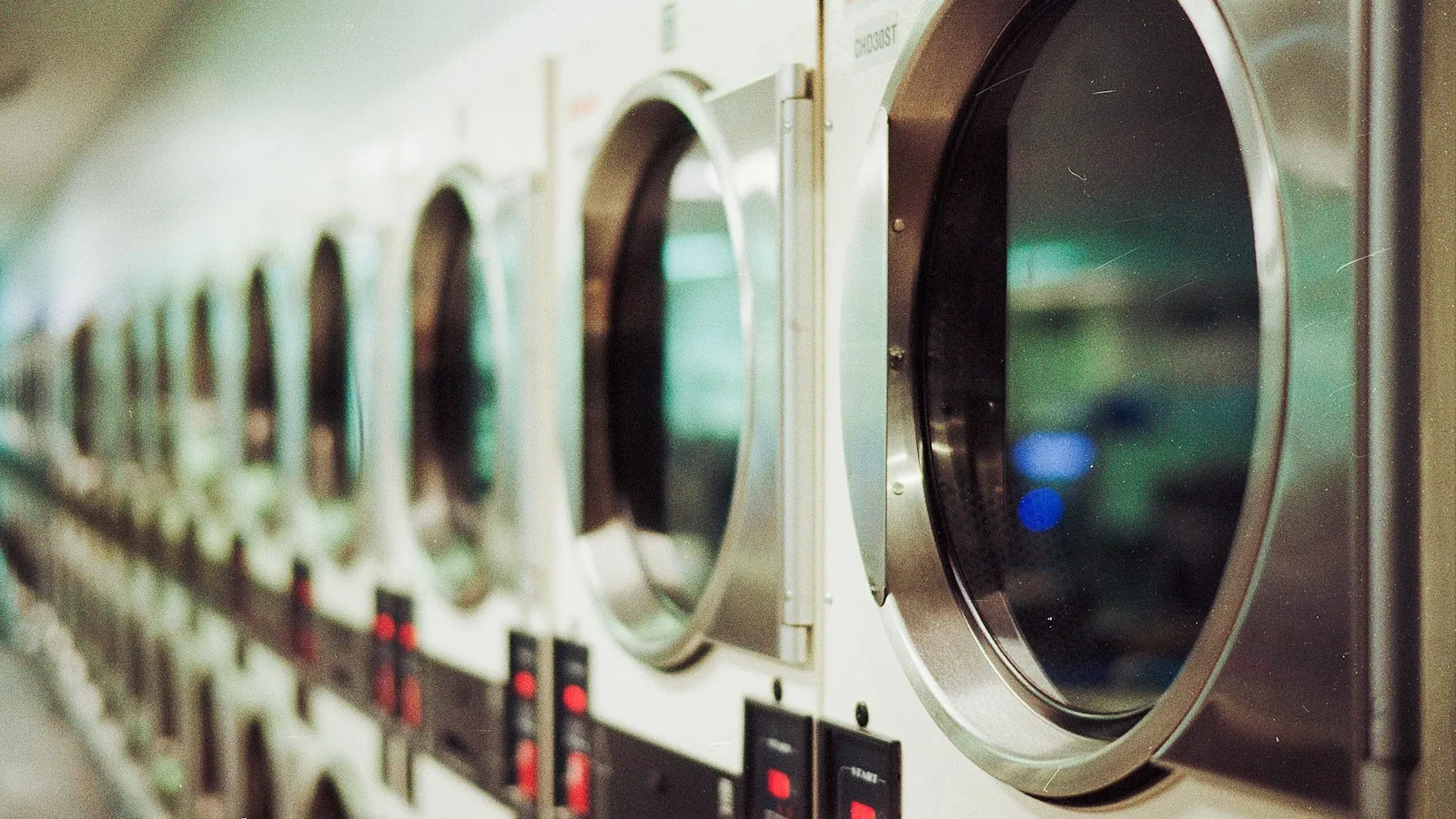 Row of front-load washing machines in a laundromat