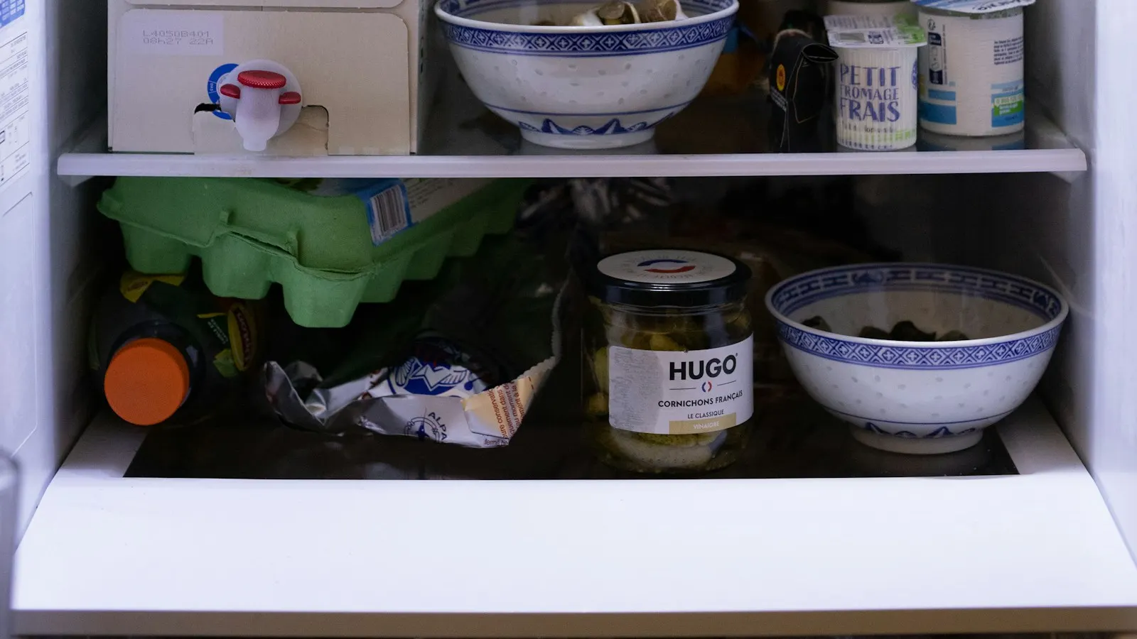 The inside of a refrigerator with shelves of food, seen from the front